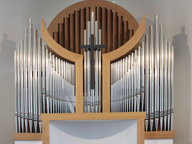 Die Orgel der Gemeinde Brandenburg stammt ursprünglich aus Berlin-Mahlsdorf: Die Holzarmaturen in zweier nach oben geöffneter Hände, das Schwellwerk als angedeutete Weltkugel haltend