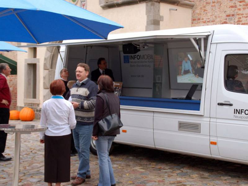 Gespräche über Glaube und Kirche unter blauen Schirmen