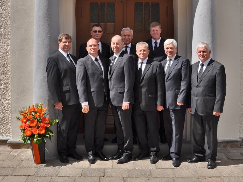 Gruppenbild der Amtsträger mit Bezirksapostel und Begleitung