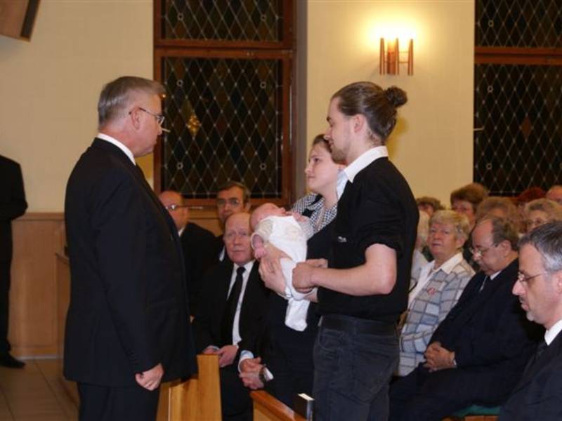Eltern mit ihrem Kind, das in diesem Gottesdienst das Sakrament der Heiligen Versiegelung empfängt