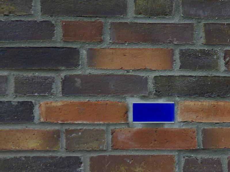 In die Klinkerfassade des Anbaus sind blaue hinterleuchtete Glassteine integriert